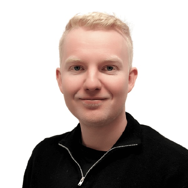 Real Cleanin Mikko Tolvanen hymyilee mustavalkoinen vetoketjupaita päällään valkoisella taustalla